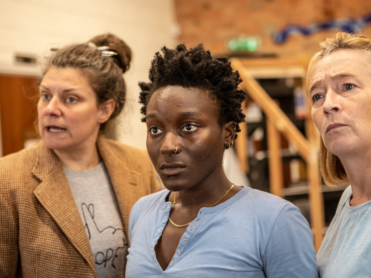 A close up of Polly, Tifé and Hilary rehearsing in character.